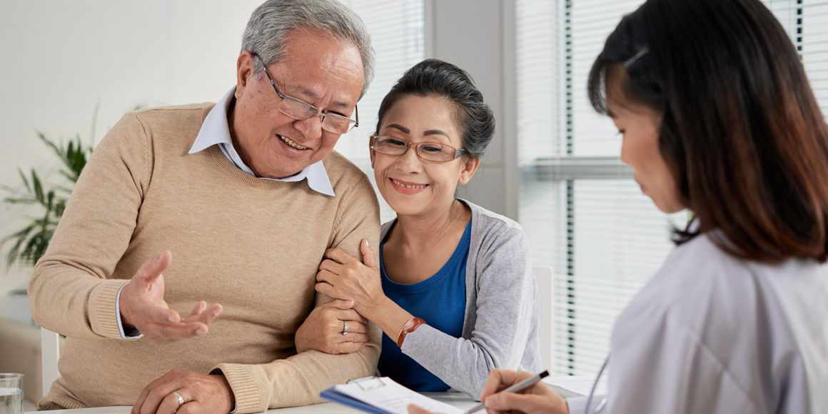 An elderly couple are sitting across from a financial advisor.