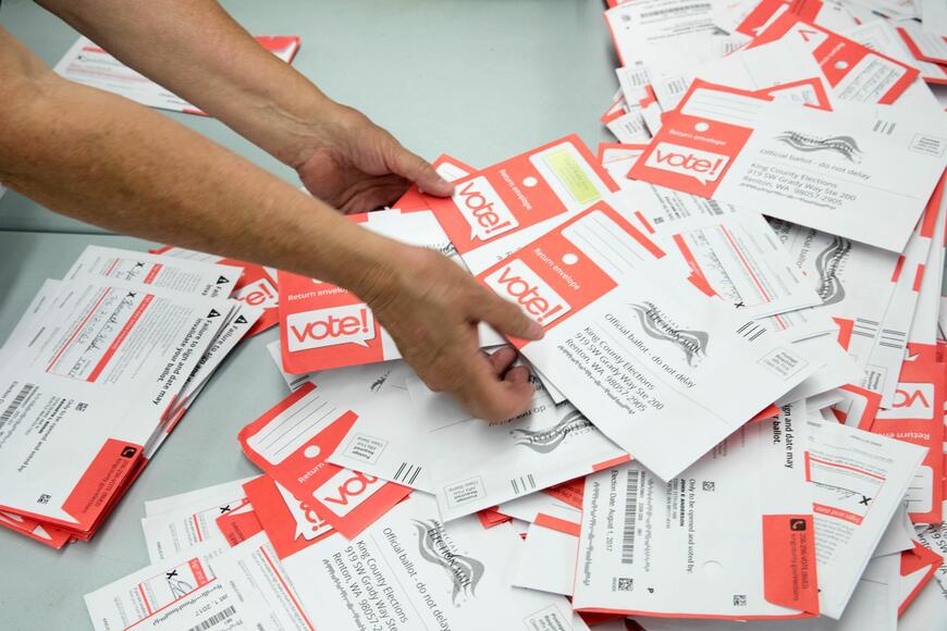 person counting voter ballots