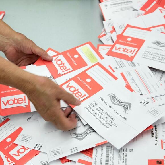 person counting voter ballots